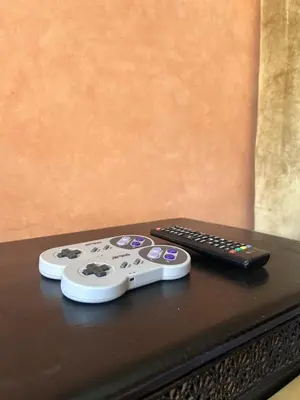 two remote controls sitting on top of a table at L'escapade Marrakech - Appartement familiale vue sur Piscine in Marrakech