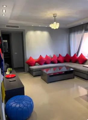 a living room with a couch with red pillows at Charming Apartment Heart of Marrakech in Marrakech