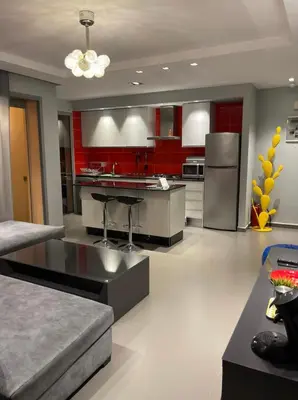 a kitchen with red cabinets and stainless steel appliances at Charming Apartment Heart of Marrakech in Marrakech