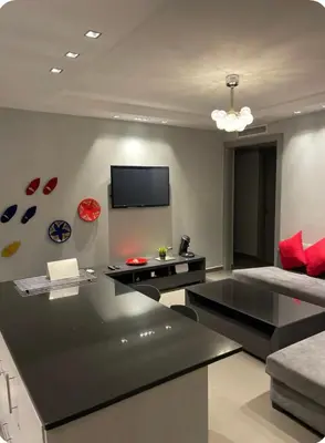 a living room with a table and a tv on the wall at Charming Apartment Heart of Marrakech in Marrakech