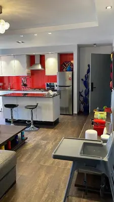 a large kitchen with red cabinets and a table at Ideal stay near Medina and historical sites in Marrakech