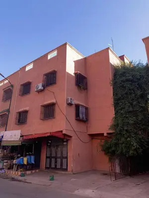 a red brick building with windows on a street at Cozy Part in Marrakech