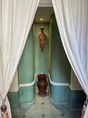 a room with green walls and a curtain and a vase at RIAD VERT de Nina in Marrakech