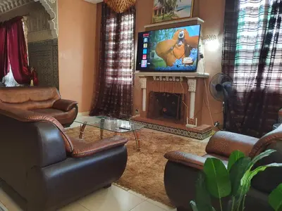 a living room with a fireplace and a tv at Villa with private pool in the center of marrakech in Marrakech