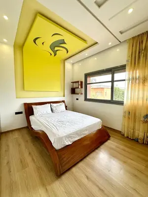 a bedroom with a bed with a yellow painting on the wall at 5-star luxury villa with private pool in Marrakech
