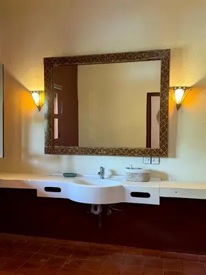a bathroom with a sink and a large mirror at Domaine JJ in Marrakech
