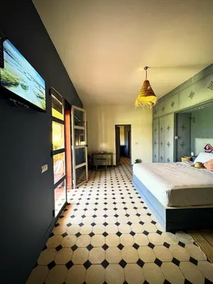 a bedroom with a bed and a flat screen tv at Domaine JJ in Marrakech