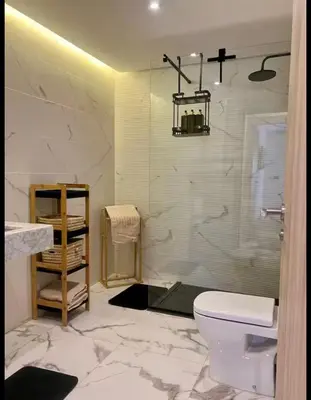 a bathroom with a toilet and a glass shower at Résidence palmeraie gates Marrakech in Marrakech