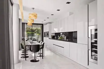 a kitchen with white cabinets and a table and chairs at Beautiful palm tree villa in Marrakech