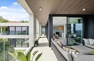 an open living room with a gray couch and glass windows at Beautiful palm tree villa in Marrakech