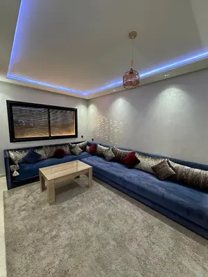 a living room with a blue couch and a table at Appartement a Marrakech centre in Marrakech