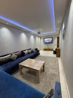 a living room with a blue couch and a table at Appartement a Marrakech centre in Marrakech