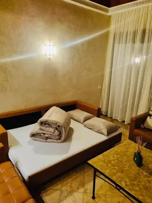 a room with a bed with a light on the wall at Palmeraie village , lieu exceptionnel avec jardin et piscine in Marrakech