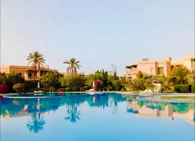 a large pool with blue water in a resort at Palmeraie village , lieu exceptionnel avec jardin et piscine in Marrakech