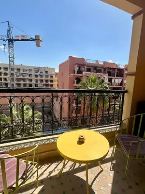 a yellow table and chairs on a balcony at apartement centre gueliz in Marrakech