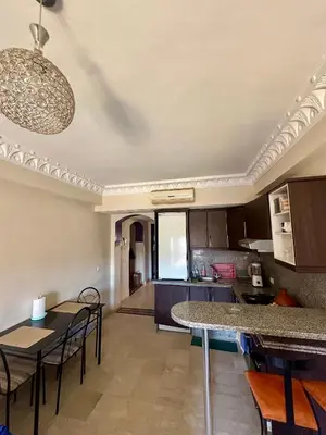a kitchen and living room with a table and chairs at apartement centre gueliz in Marrakech