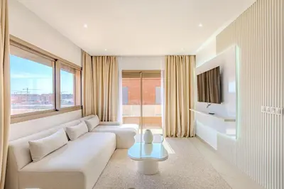 a living room with a white couch and a large window at Magnifique appartement moderne 1 chambre proche de la gare de Gueliz in Marrakech
