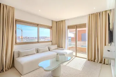 a living room with a white couch and a glass table at Magnifique appartement moderne 1 chambre proche de la gare de Gueliz in Marrakech