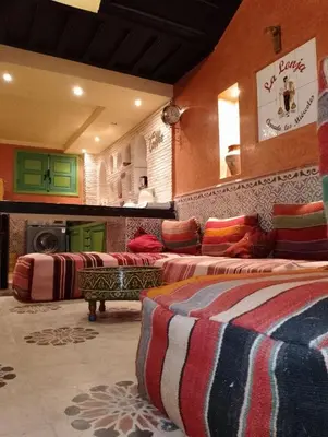 a room with three beds with colorful pillows in it at Riad Yousra in Marrakech