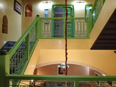 a spiral staircase with green railings in a building at Riad Yousra in Marrakech