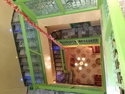 a green room with a chandelier in it at Riad Yousra in Marrakech