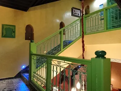 a staircase with green railings in a building at Riad Yousra in Marrakech