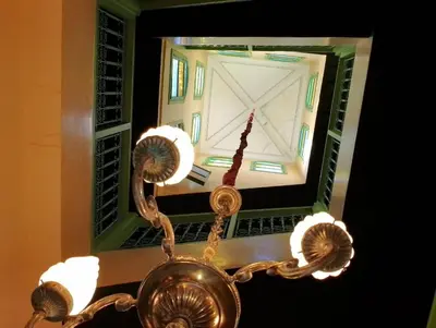 a chandelier in front of a window with a clock at Riad Yousra in Marrakech