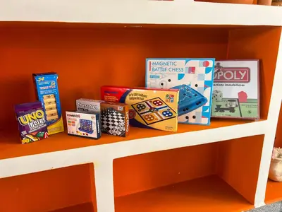 a shelf filled with lots of games and toys at Maison Zen 4 Suites, Private Indoor Pool, Jacuzzi & Gym, Central Marrakech in Marrakech
