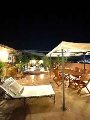 a patio with chairs and umbrellas at night at Rooftop Sun Pool Chic Apartment Perfect Stay in Marrakech
