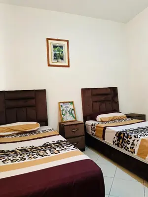 two beds sitting next to each other in a room at Appartement a louer in Marrakech