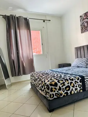 a bedroom with a bed with a cheetah blanket at Appartement a louer in Marrakech