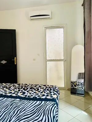 a bedroom with a zebra print bed and a window at Appartement a louer in Marrakech