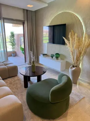 a living room with a green chair and a table at Elegant Apartment in Prestigia Pool & Golf in Marrakech
