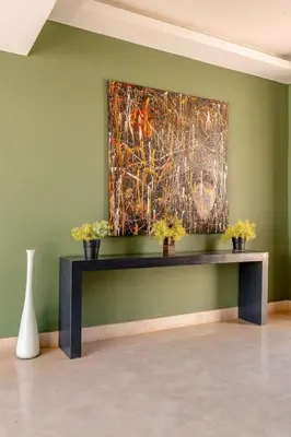 a painting on a green wall with potted plants at Villa Sofya Domaine exceptionnel 10 suites & piscine privée in Marrakech