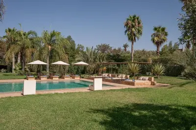 a pool with chairs and umbrellas in a yard at Villa Sofya Domaine exceptionnel 10 suites & piscine privée in Marrakech