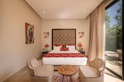 a bedroom with a large bed and two chairs at Villa Sofya Domaine exceptionnel 10 suites & piscine privée in Marrakech