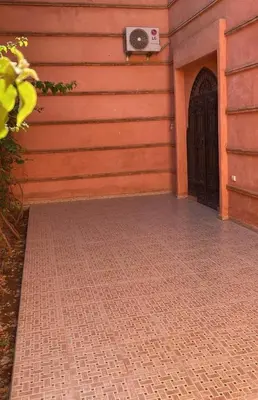 a building with a black door and a brick sidewalk at Villa Route de Casa in Marrakech