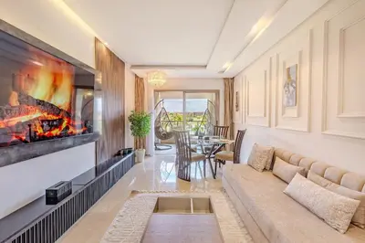 a living room with a couch and a fireplace at Luxury Apartment - Prestigia Golf City Marrakech in Marrakech