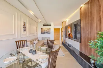 a dining room with a table and chairs and a couch at Luxury Apartment - Prestigia Golf City Marrakech in Marrakech