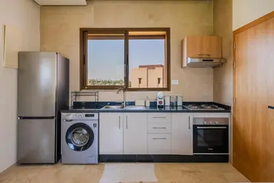 a kitchen with a stainless steel refrigerator and a dishwasher at Prestigia Apartment Secure Residence Pool in Marrakech