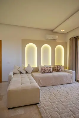 two beds in a living room with a couch at Prestigia Apartment Secure Residence Pool in Marrakech