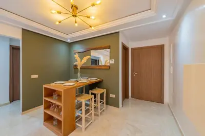 a dining room with a table and a mirror at Rooftop piscine-new appartment - centre ville in Marrakech