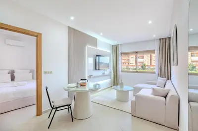 a white room with a bed and a table and a couch at Appartement 1 chambre proche de la gare de Gueliz in Marrakech