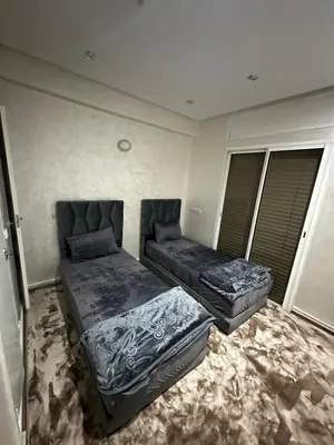 a bedroom with two beds and a couch at Achraf in Marrakech