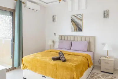 a bedroom with a bed with a pair of shoes on it at Kridarek - Appartement d'exception à Marrakech in Marrakech