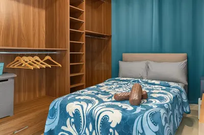 a bedroom with a bed with a blue and white comforter at Kridarek - Appartement d'exception à Marrakech in Marrakech