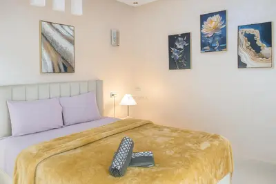 a bedroom with a bed with a remote control on it at Kridarek - Appartement d'exception à Marrakech in Marrakech