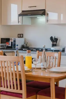 a wooden table with glasses and bottles on it in a kitchen at 2BR NEW Luxury apartment CityCenter in Marrakech