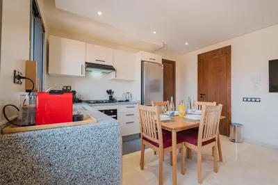 a kitchen with a table and chairs in a kitchen at 2BR NEW Luxury apartment CityCenter in Marrakech