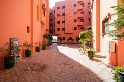an empty alley with potted plants and buildings at 5-min away to Marrakech Airport in Marrakech